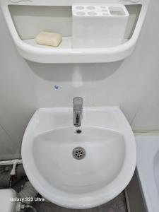 a bathroom with a white toilet with a sink at Kamkor in Atyrau