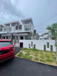 a red car parked in a parking lot in front of a building at BOSS Homestay 