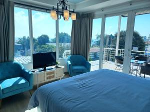 ラン島にあるKoh Larn Rivieraのベッドルーム1室(ベッド1台、椅子2脚、テレビ付)