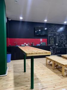 a kitchen with a large wooden table and benches at Salut Hotel in Bishkek
