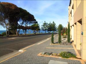 an empty street next to a building with the ocean at Sally's Kingscote Retreat-2 units with 4 bedrooms in Kingscote, Kangaroo Island in Kingscote