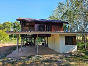 a small house with a porch and a motorcycle in front at NADOHN2 Nai Fan Homestay in Rayong