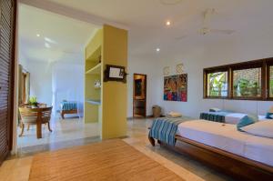 a bedroom with two beds and a living room at Villa Batu Tangga in Amed