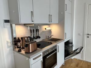 a kitchen with white cabinets and a sink at Gemütliche Wohnung mit Terrasse in Blumberg