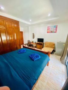 a bedroom with a blue bed and a couch at BT hotel Kata Beach in Kata Beach