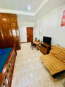 a bedroom with a bed and a desk with a computer at BT hotel Kata Beach in Kata Beach