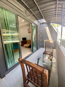 a dining room with a glass table and two chairs at BT hotel Kata Beach in Kata Beach