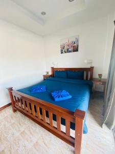 een slaapkamer met een blauw bed met blauwe lakens bij BT hotel Kata Beach in Kata Beach