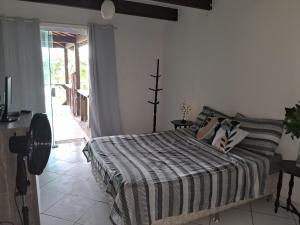 1 dormitorio con 1 cama con edredón blanco y negro en Casa da Praia em Costazul en Rio das Ostras