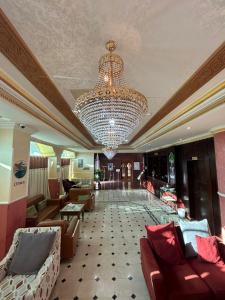 um grande átrio com um lustre e sofás em Safari Hotel em Nizwa