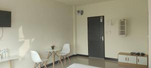 a room with a black door and a table and chairs at TPR51 Room Service in Ban Hua Khao Sammuk