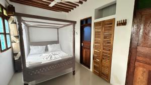 ein Schlafzimmer mit einem Himmelbett in einem Zimmer in der Unterkunft Light of Zanzibar Hotel in Nungwi
