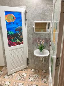 a bathroom with a fish painting on the wall at เดอะมินิมอล นอร์ดิกเฮ้าส์The Minimal Nordic House By The Mountain Ozoneบ้านโอโซนขุนเขาแก่งกระจาน in Kaeng Krachan