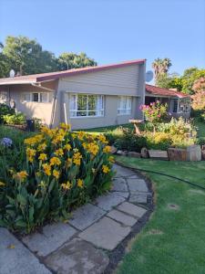 a house with yellow flowers in the front yard at Nandi's Place in Harrismith