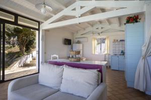 een woonkamer met een bank en een keuken bij Stunning apartment in the nature with dreamy view in Parrinello 