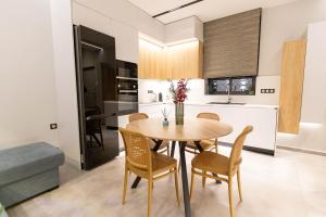 a kitchen and dining room with a wooden table and chairs at BillMar Luxury Apartment in the center of Gythio in Gythio