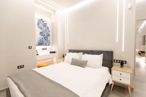 a bedroom with a white bed and a blue painting at BillMar Luxury Apartment in the center of Gythio in Gythio