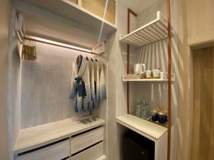 a walk in closet with white cabinets and blue towels at Tohsang Heritage Khongjiam in Khong Chiam