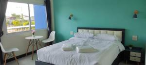 Un dormitorio azul con una cama grande con toallas. en TPR51 Room Service, en Ban Hua Khao Sammuk