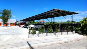 a pavilion with potted plants in a parking lot at TPR51 Room Service in Ban Hua Khao Sammuk