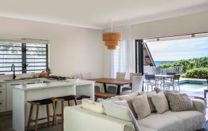 Centre de Flacq的住宿－Beach Villa Poema，厨房以及带沙发和桌子的客厅。