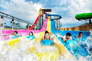 a group of people riding a water slide at a water park at Hangout Villas in Lonavala