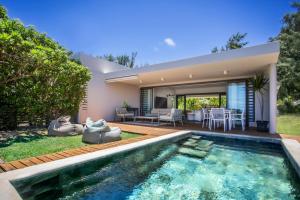 a backyard with a swimming pool and a house at Beach Villa Poema in Centre de Flacq