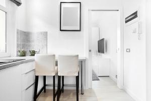 a kitchen with a table and two white chairs at Pegaz 4 in Sopot