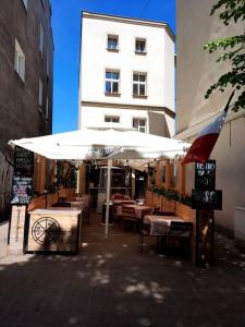 ソポトにあるPegaz 4の建物の前にあるレストラン(テーブルと傘付)