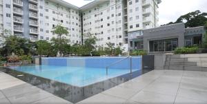 a swimming pool in front of a building at Tiny Haven Room in Tunkong Manga