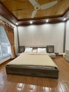 a bedroom with a large bed with a ceiling at Roof Top Resort in Murree