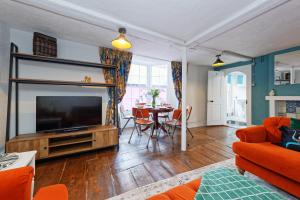 a living room with a television and a table with chairs at Northern Belle four Bedroom Apartment in Margate