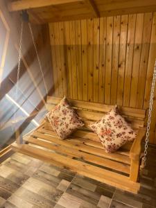 two pillows on a wooden swing in a sauna at اكواخ طرابزون عجلون in Jerash