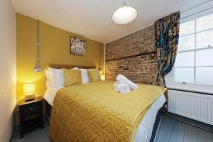 a bedroom with a large bed with a brick wall at Northern Belle four Bedroom Apartment in Margate