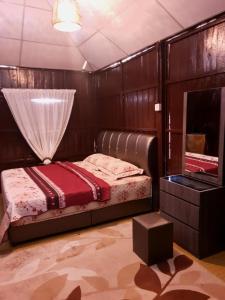 a bedroom with a bed and a mirror at Rumah Kayu Aboh in Kuala Terengganu