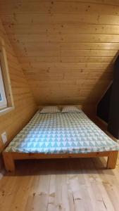 Łóżko w drewnianym pokoju z drewnianą podłogą w obiekcie Domek górski na Polanie Goryczkowej 700 m npm - Szczyrk dojazd samochodem terenowym, w zimie utrudniony - wymagane łańcuchy w Szczyrku