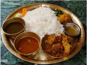 um prato de alimentos com arroz e diferentes tipos de alimentos em TAMANG FAMILY HOMESTAY VL BED & BREAKFAST, DARJEELING em Darjeeling