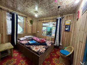 um quarto com uma cama num quarto de madeira em TAMANG FAMILY HOMESTAY VL BED & BREAKFAST, DARJEELING em Darjeeling