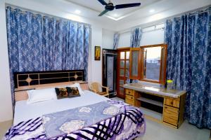 a bedroom with a bed and a desk and a window at Bhagora CJMA Home Stay/Villa in Udaipur