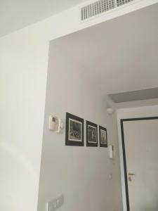 une chambre avec trois photos sur un mur blanc dans l'établissement Appartamento con terrazzo privato Milano San Raffaele Linea verde, à Vimodrone