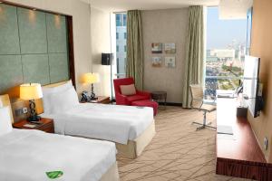 Łóżko lub łóżka w pokoju w obiekcie Millennium Plaza Doha