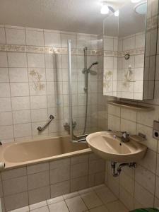 La salle de bains est pourvue d'une baignoire, d'un lavabo et d'une douche. dans l'établissement Titisee Traumblick, à Hinterzarten