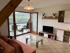 a living room with a couch and a glass table at Titisee Traumblick in Hinterzarten