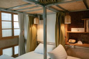 台南的住宿－365.合日旅所，一间卧室设有一张四柱床和窗户