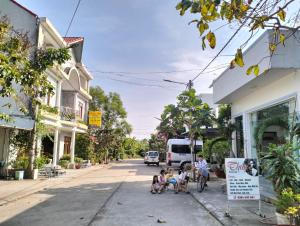 a group of people sitting on the side of a street at Khách Sạn Hưng Yên in Phu Quoc