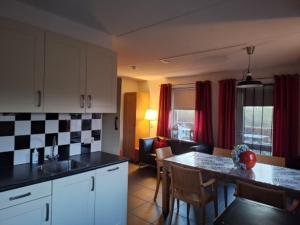 een keuken met een tafel en een woonkamer bij Hoeve Montigny B&B in Giethoorn