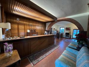 een woonkamer met een bank en een bar bij Hotel Villalago trasimeno in Magione
