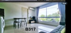 バンサレーにあるBangsaray Beach Resortのリビングルーム(テーブル、椅子、窓付)