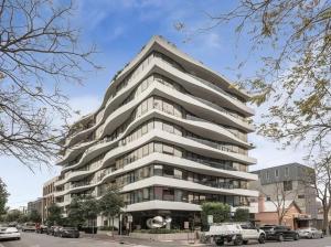 un edificio blanco alto con coches estacionados frente a él en Apartment in South Melbourne en Melbourne