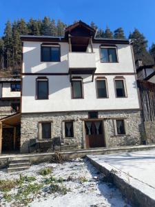 a house in the mountains with snow on the ground at Star Dust in Shiroka Laka